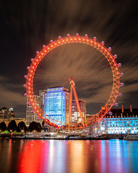 Illuminated ferris wheel in city at night