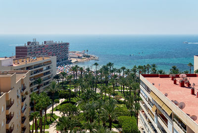 High angle view of buildings and sea against clear sky