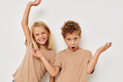 Portrait of cheerful sibling against white background