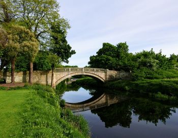 Arch bridge over river against sky