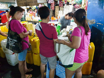 Rear view of people standing in market