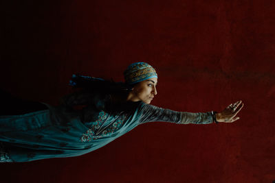 Young woman in traditional clothing against gray background