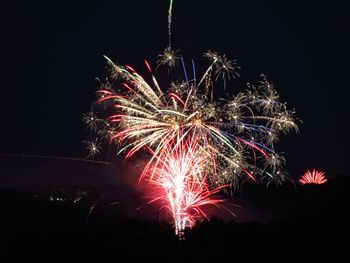 Low angle view of firework display at night