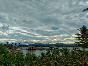 Houses by lake against sky