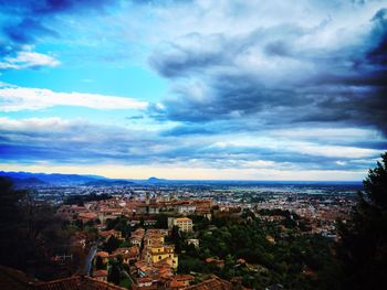 View of cityscape against cloudy sky