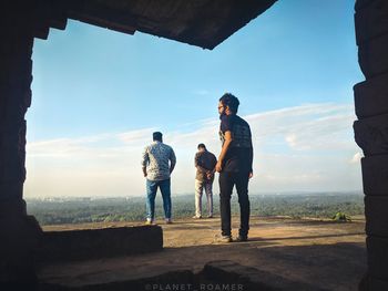 Men standing at park against sky