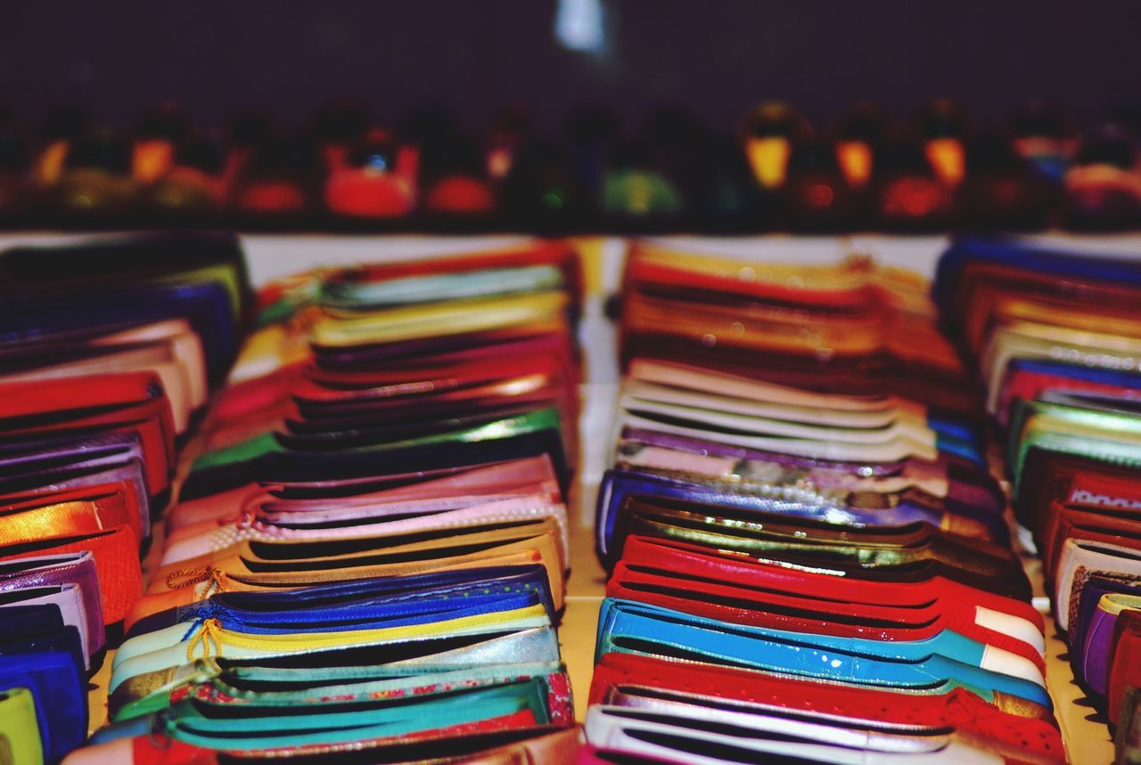 indoors, large group of objects, multi colored, variation, still life, in a row, choice, abundance, arrangement, stack, order, close-up, collection, repetition, colorful, for sale, retail, selective focus, group of objects, no people