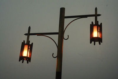 Low angle view of illuminated street light against sky