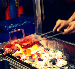 Person preparing food on barbecue grill