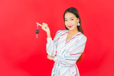 Portrait of a smiling young woman against red background