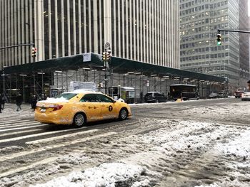 Yellow car on snow covered city