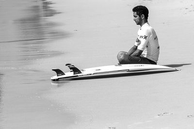 Side view of man sitting on boat in lake