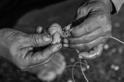 Close-up of hands preparing fishing tackle