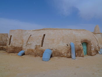 Old ruins on beach against blue sky