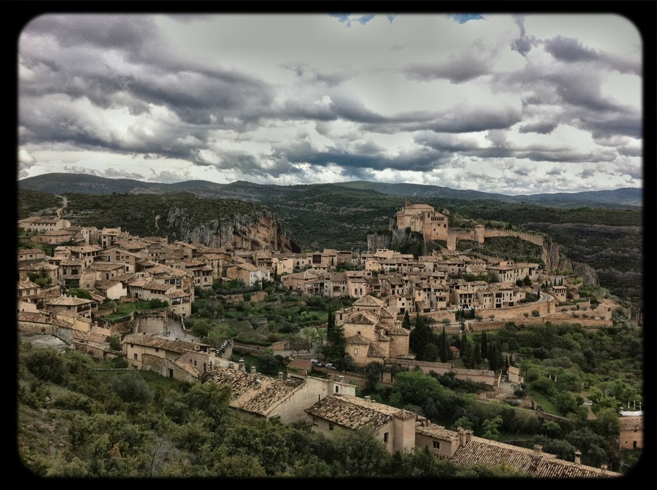 transfer print, building exterior, architecture, built structure, sky, auto post production filter, mountain, cloud - sky, high angle view, house, cloudy, residential structure, town, cloud, residential district, townscape, landscape, residential building, mountain range, cityscape