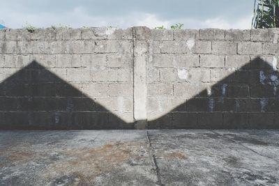 Shadow of person on wall against sky