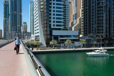 Man on river amidst buildings in city