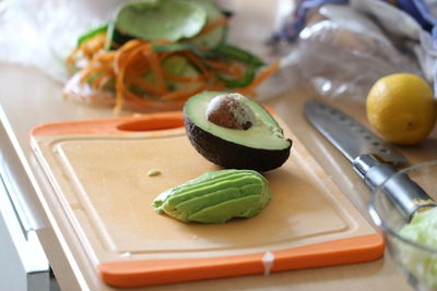 Close-up of fresh avocado on cutting board in kitchen at home