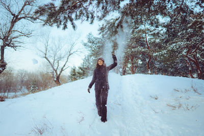 Young woman enjoying winter weather in the snow forest. cold weather. winter holidays