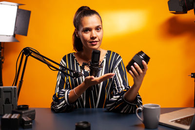 Portrait of young woman using mobile phone while sitting in cafe