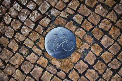 High angle view of bicycle sign on paving stone street in barcelona