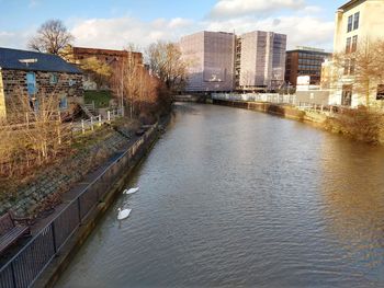 River amidst buildings in city against sky