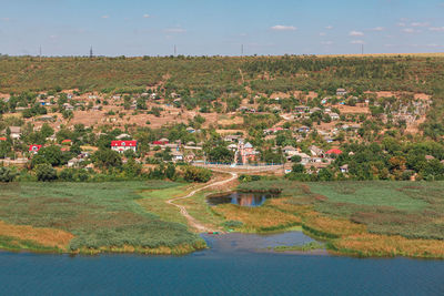 Green village situated at the riverside . rustic coastal scenery . fishing village landscape