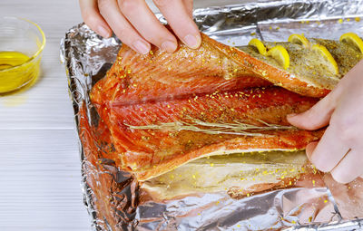 Cropped hands of woman preparing seafood on table