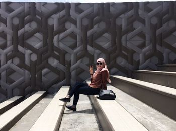 Full length portrait of young man sitting outdoors