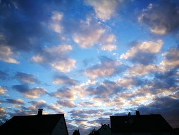 Low angle view of silhouette roof against sky