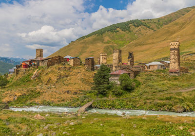 Built structure on field by mountain against sky