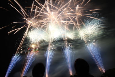 Low angle view of firework display at night