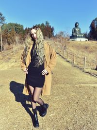 Full length of young woman standing on field