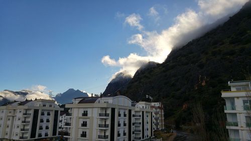 Buildings in town against cloudy sky