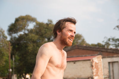 Portrait of shirtless bearded man smiling