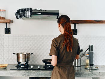 Rear view of young woman using mobile phone in cafe