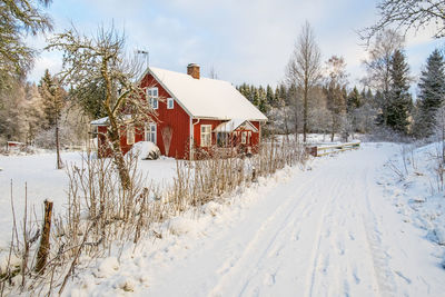 Red house at the roadside in snowy winter landscape