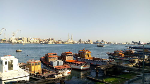 High angle view of cityscape by sea against clear sky