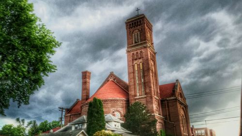 Low angle view of clock tower against cloudy sky