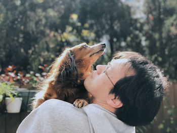 Midsection of woman with dog against blurred background