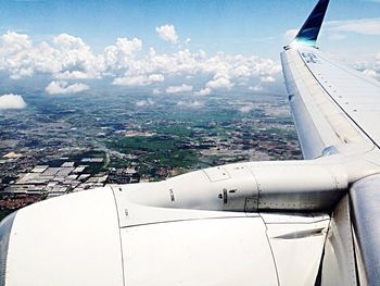 Cropped image of airplane flying over cityscape