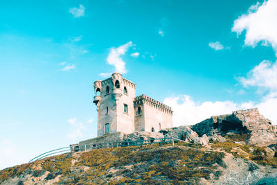 Low angle view of historic building against blue sky