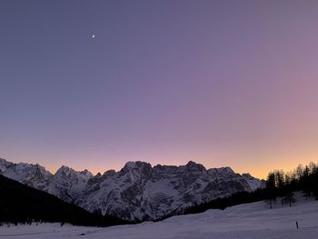 Scenic view of snowcapped mountains against sky during sunset