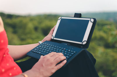 Midsection of woman using laptop