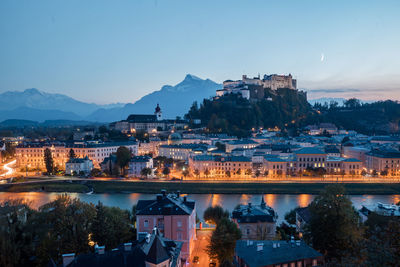 Illuminated buildings in city at dusk