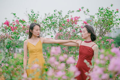 Beautiful woman standing by flowering plants