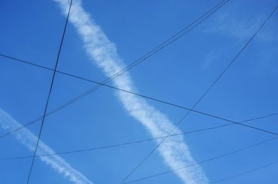 Low angle view of vapor trail against blue sky