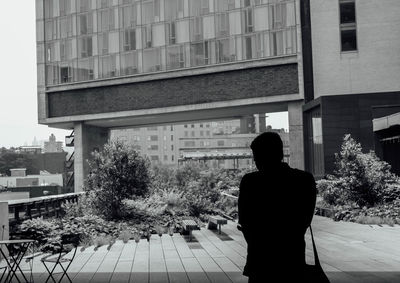 Rear view of man standing in front of building