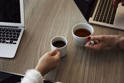 Women's hands holding cups