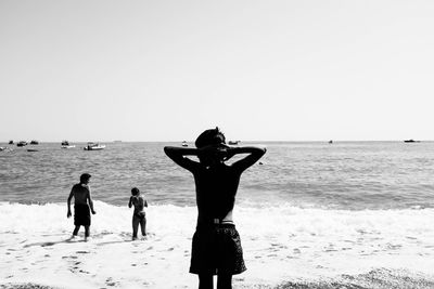 People on beach against clear sky